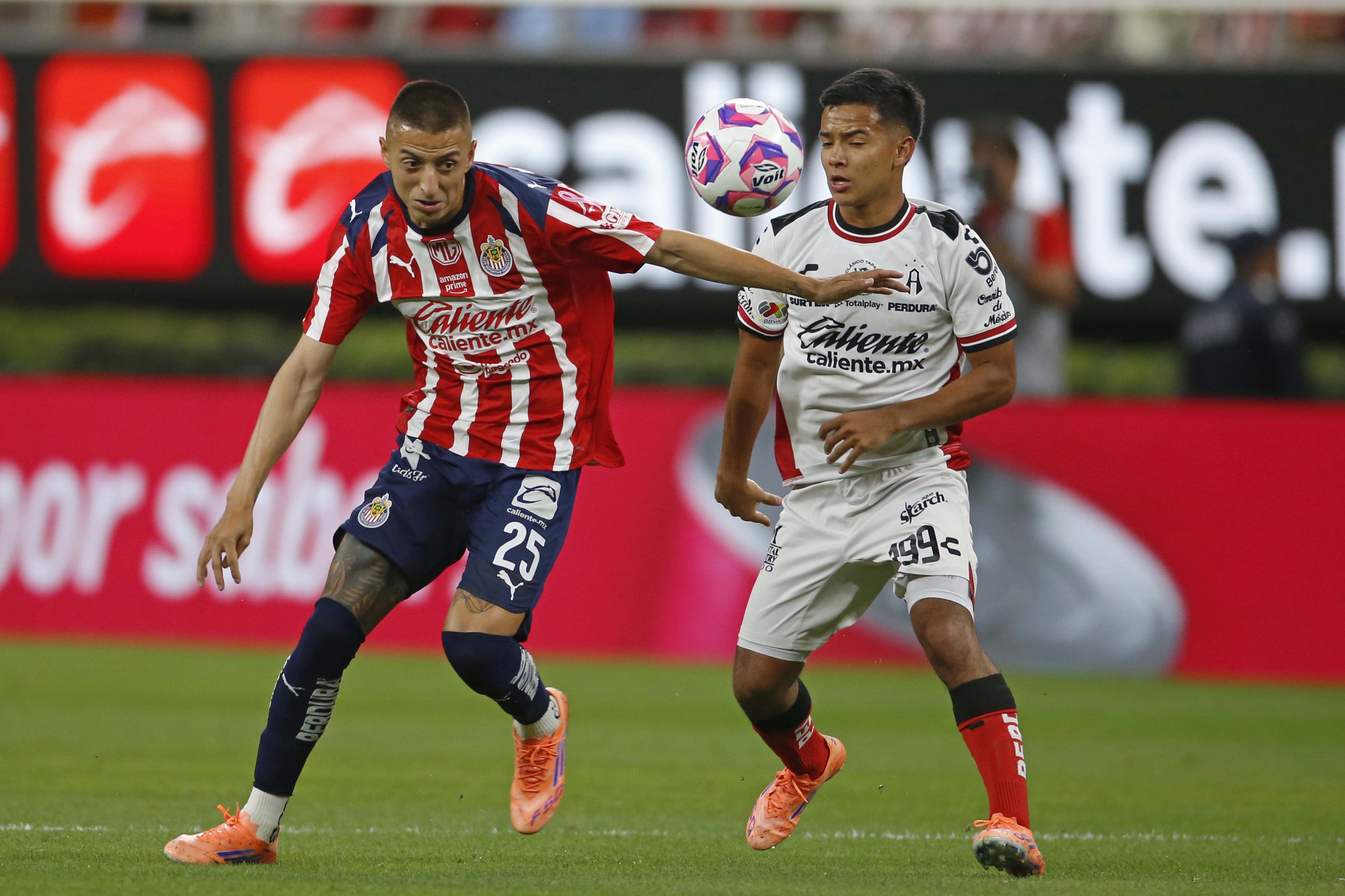 ZAPOPAN, JALISCO, 25OCTUBRE2025.- Roberto Alvarado jugador de Chivas disputa el balón con el contrario de Atlas Sergio Hernandez, esto en partido correspondiente jornada 13 del Torneo Apertura 2025 de la Liga MX, en donde se enfrentan los equipos de Chivas vs Atlas y en juego que se lleva a cabo en el Estadio Akron, el marcador al momento es de 3-0 a favor del equipo de casa.